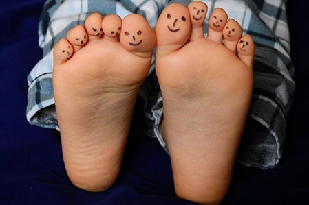 Symbolfoto Füße, mit Smilys bemalte Zehen
