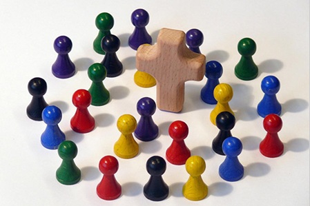 Symbolfoto Spielfiguren/Kegel versammelt um Kreuz