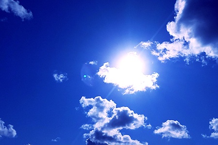 Symbolbild: Sonne und Wolken am blauen Himmel