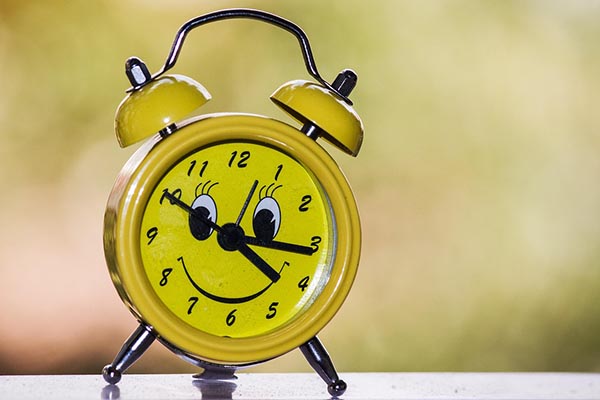 gelber Wecker mit gelbem Smiley-Gesicht