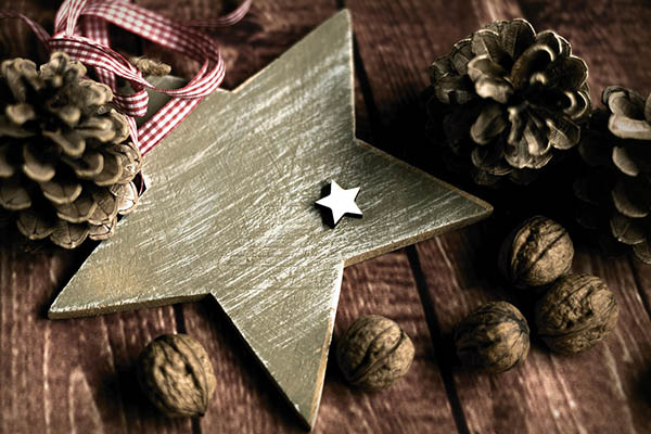 adventliche Dekoration: Holzstern, Walnüsse und Tannenzapfen
