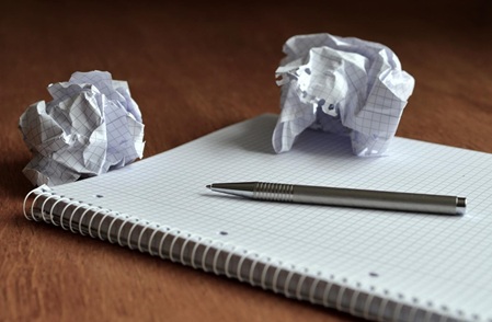Symbolbild Papierblock, Stift, zerknülltes Papier